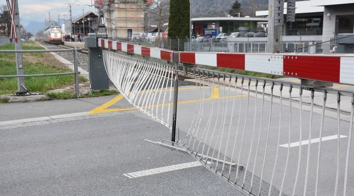 Bahnschranke senkt sich auf Autodach
