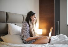 Foto von Andrea Piacquadio: https://www.pexels.com/de-de/foto/seitenansicht-foto-der-lachelnden-frau-in-einem-schwarz-weiss-gestreiften-oberteil-das-auf-einem-bett-sitzt-wahrend-man-einen-laptop-benutzt-3765035/