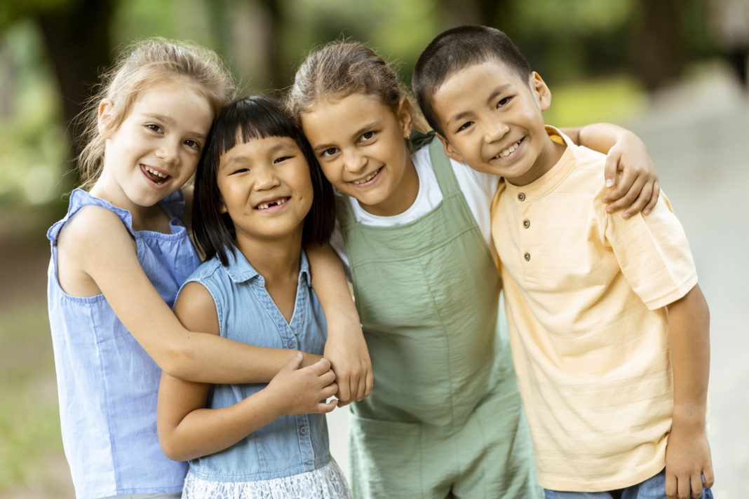 Group of asian and caucasian kids having fun in the park