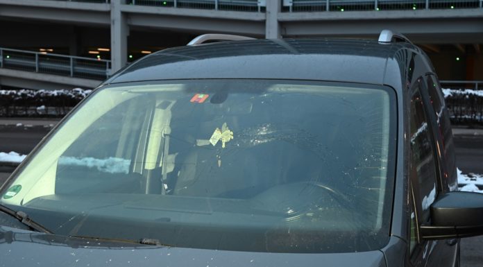 Gegenstand von Brücke auf fahrendes Auto geworfen